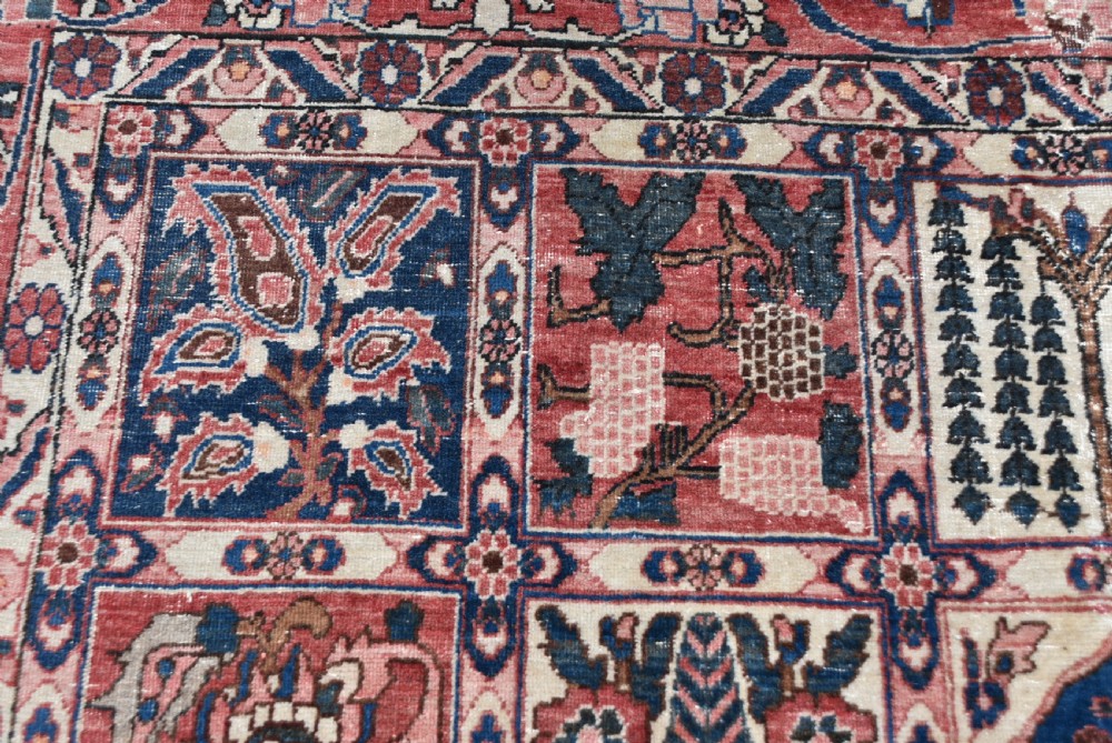 A hand-knotted Persian wool rug featuring a grid panel design with tree and floral motifs enclosed by a detailed terracotta border. View XII
