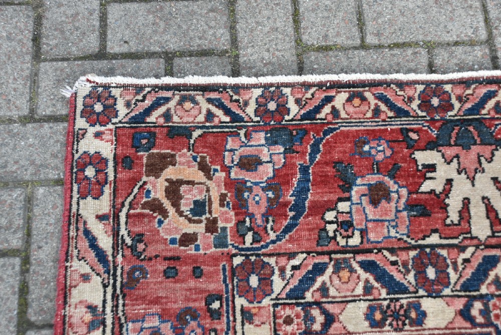 A hand-knotted Persian wool rug featuring a grid panel design with tree and floral motifs enclosed by a detailed terracotta border. View XIII