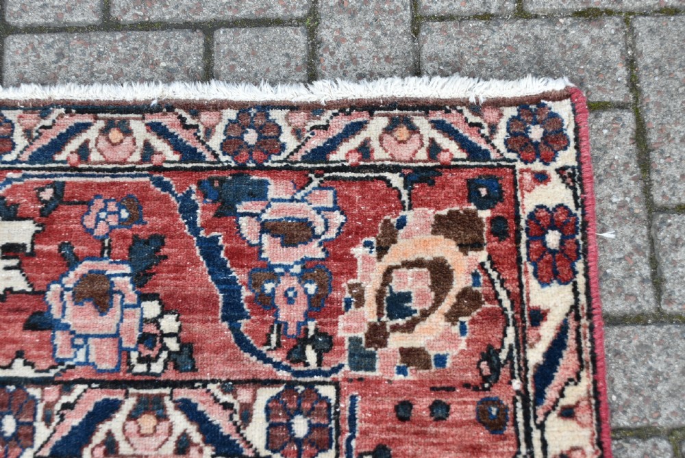 A hand-knotted Persian wool rug featuring a grid panel design with tree and floral motifs enclosed by a detailed terracotta border. View XIV