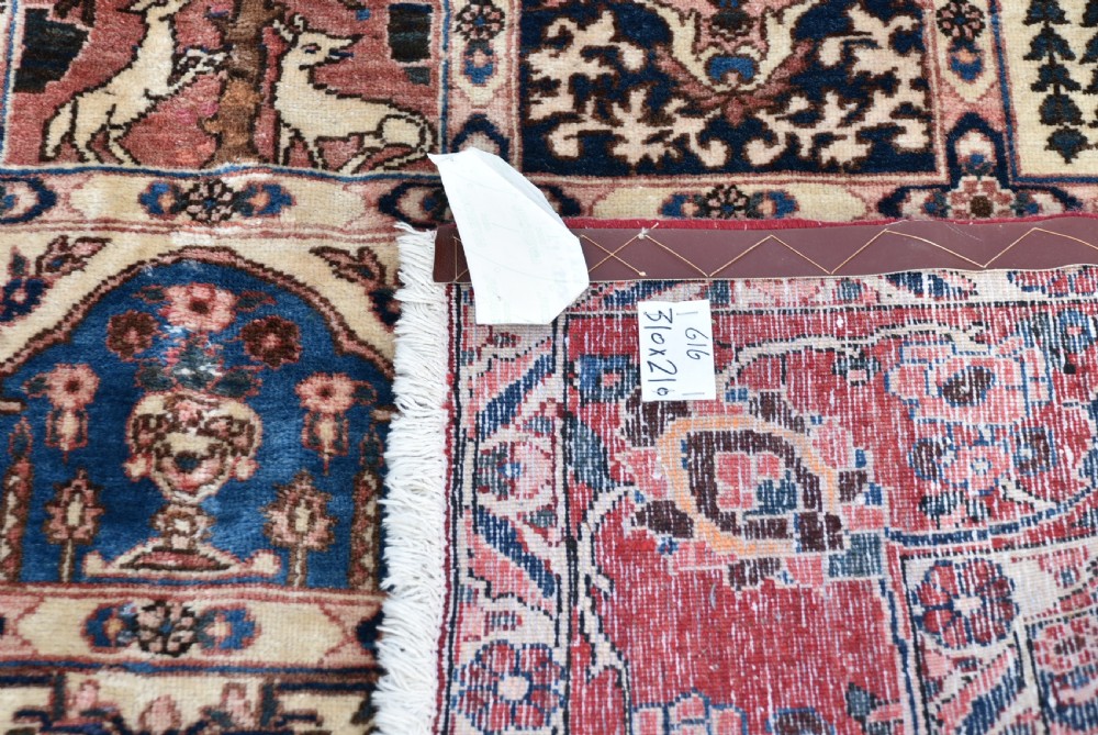 A hand-knotted Persian wool rug featuring a grid panel design with tree and floral motifs enclosed by a detailed terracotta border. View XV