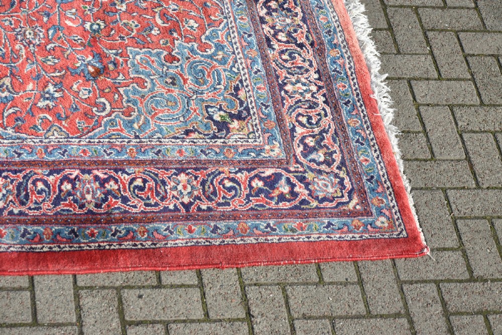 A large hand-knotted vintage Persian rug featuring a central dark blue medallion surrounded by a detailed red field filled with floral arabesque patterns and framed by intricate borders. View III