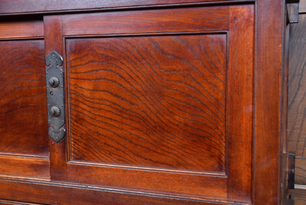 A stacked three-tier Japanese Tansu storage cabinet made of rich warm brown wood with iron handles and sliding panel doors. View II