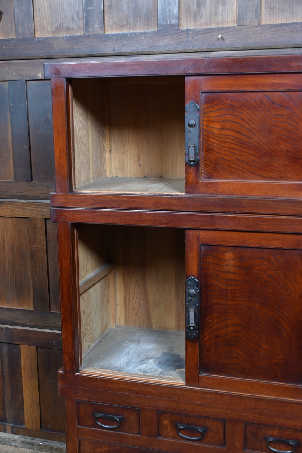 A stacked three-tier Japanese Tansu storage cabinet made of rich warm brown wood with iron handles and sliding panel doors. View VIII