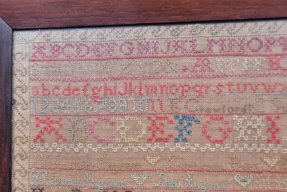 An early nineteenth-century framed Scottish needlework sampler featuring embroidered alphabets, names, dates, and tree motifs on linen. View II