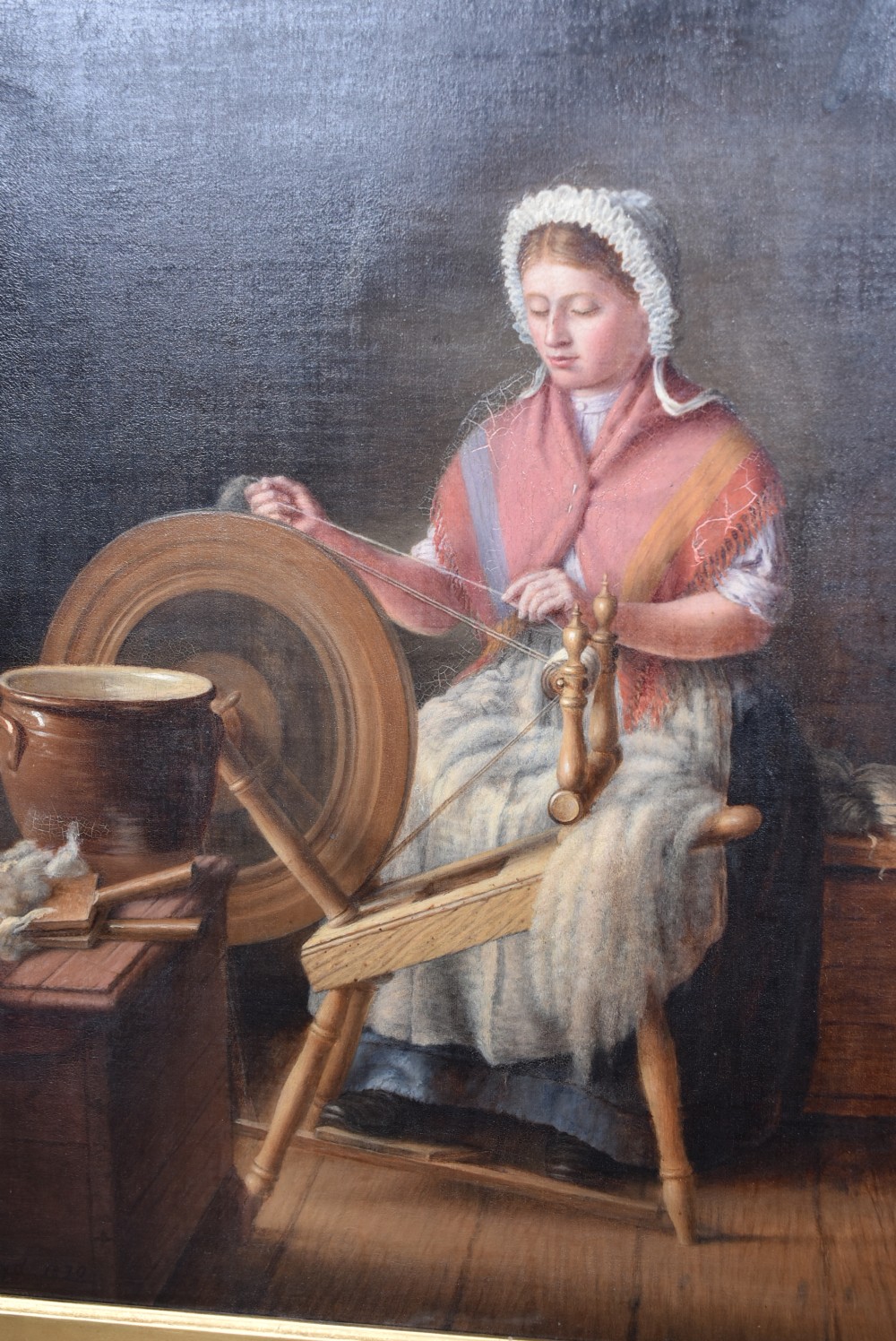 A 19th-century oil painting on wood panel by James Kyd depicting a woman operating a spinning wheel inside a cottage, set within an ornate gilded frame. View II