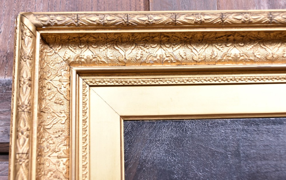 A 19th-century oil painting on wood panel by James Kyd depicting a woman operating a spinning wheel inside a cottage, set within an ornate gilded frame. View IV