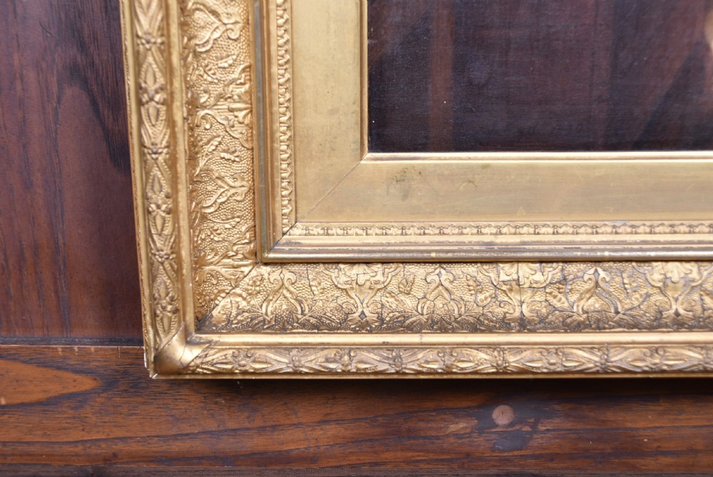 A 19th-century oil painting on wood panel by James Kyd depicting a woman operating a spinning wheel inside a cottage, set within an ornate gilded frame. View VII