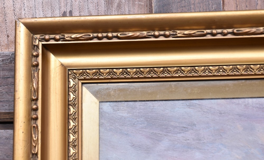 A framed oil painting depicting a herd of cattle grazing in a field beneath a dusk sky, enclosed within a decorative gold gilt frame. View V