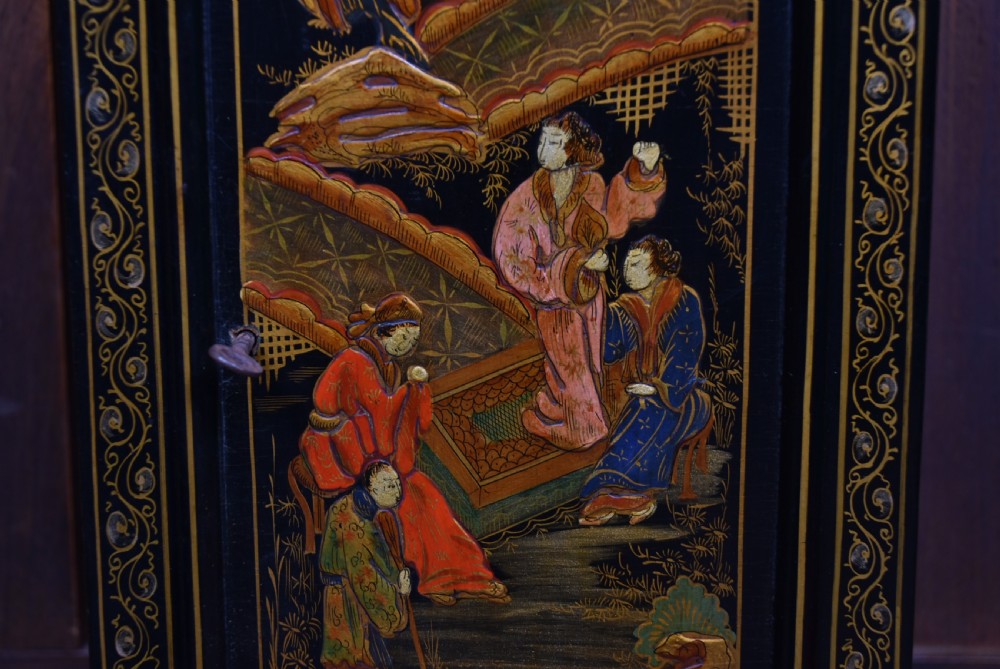 A slim black lacquered grandmother clock featuring hand-painted gilt chinoiserie landscape decoration, an arched hood, and a Roman numeral dial. View VIII