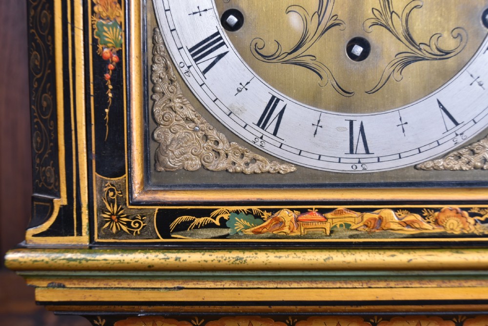 A slim black lacquered grandmother clock featuring hand-painted gilt chinoiserie landscape decoration, an arched hood, and a Roman numeral dial. View XXVII