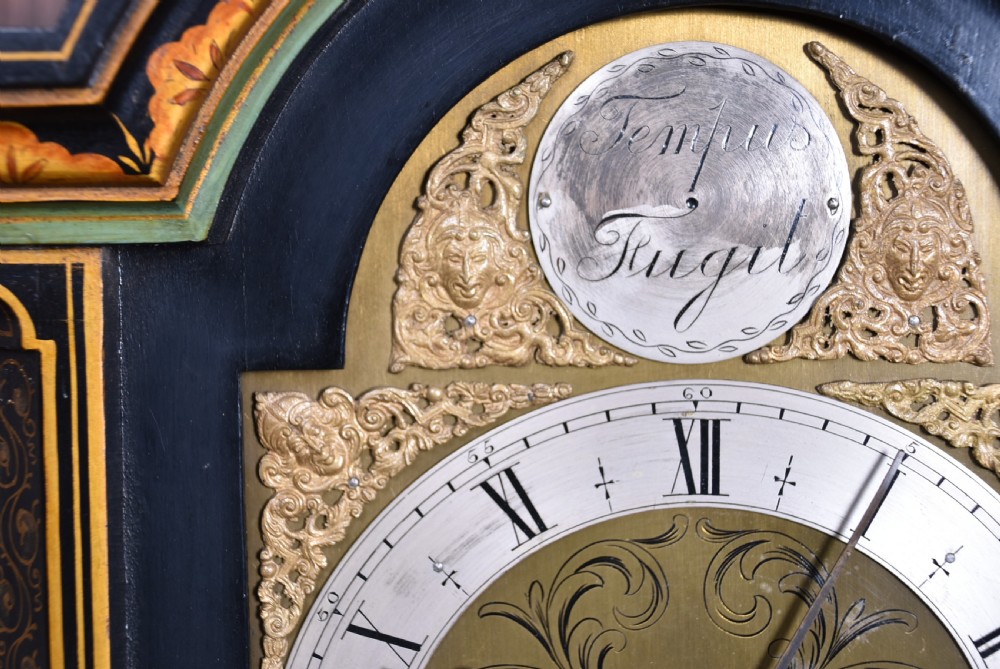 A slim black lacquered grandmother clock featuring hand-painted gilt chinoiserie landscape decoration, an arched hood, and a Roman numeral dial. View XXVIII