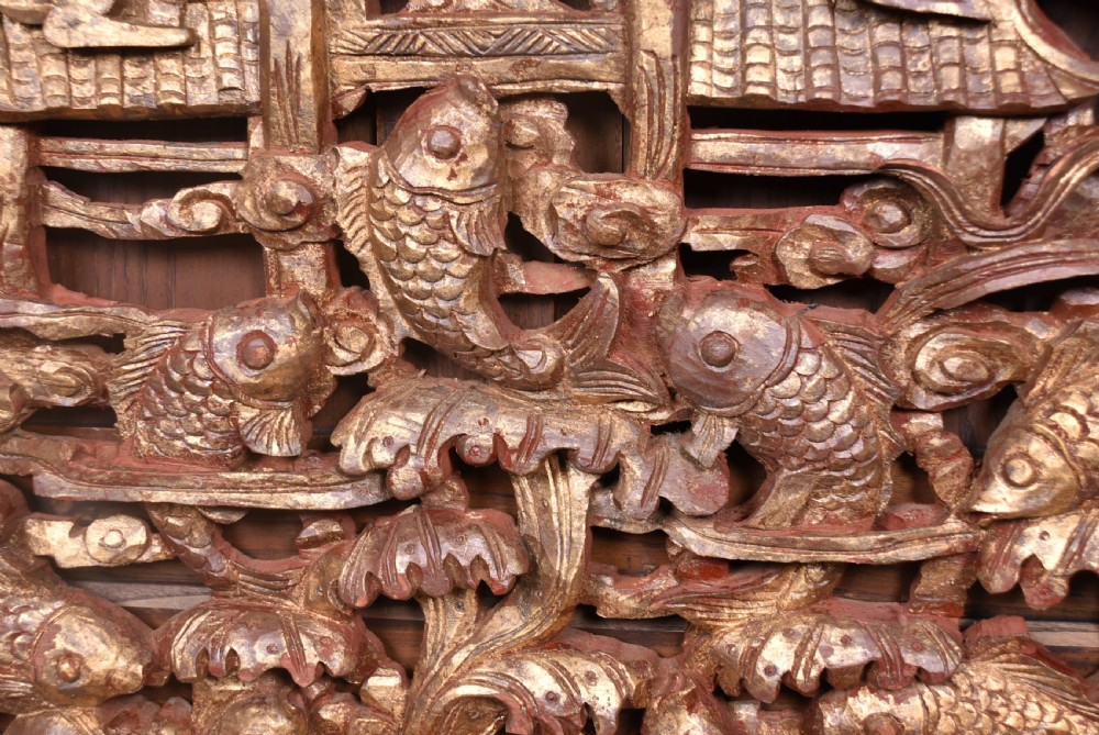 A circular 19th-century Chinese carved wooden wall plaque featuring gilded relief carvings of a dragon, carp, and pagodas. View III
