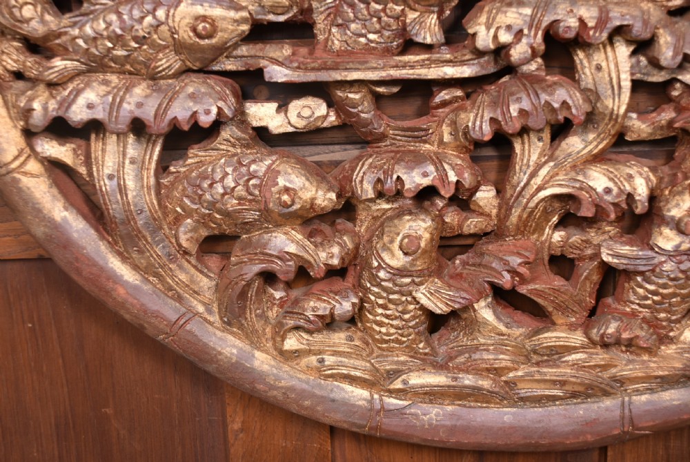 A circular 19th-century Chinese carved wooden wall plaque featuring gilded relief carvings of a dragon, carp, and pagodas. View IV