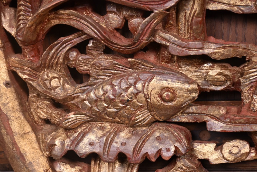 A circular 19th-century Chinese carved wooden wall plaque featuring gilded relief carvings of a dragon, carp, and pagodas. View V