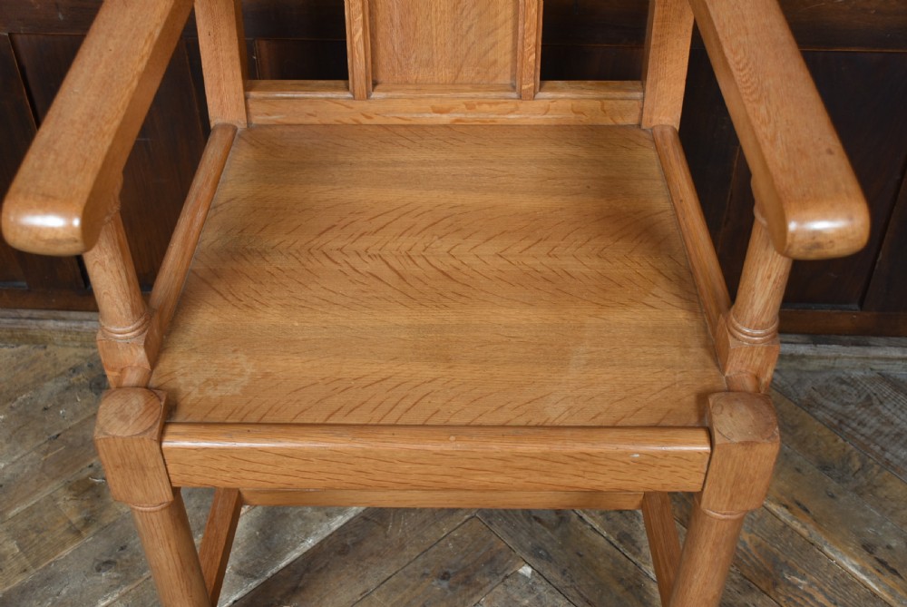 A solid oak throne chair featuring a high back decorated with three carved gothic lancet arches, straight armrests, and turned front legs joined by lower stretchers. View VII
