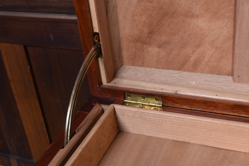 A rectangular reddish brown timber blanket box featuring carved Chinese character panels and polished brass corner fittings and straps. View XIV