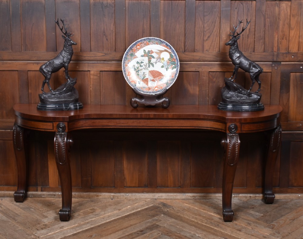 A 19th-century mahogany console table featuring a shaped top, inlaid frieze, and four carved scroll legs. View II
