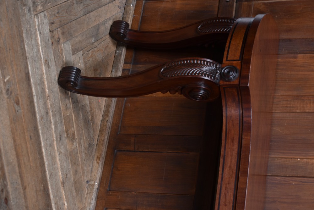 A 19th-century mahogany console table featuring a shaped top, inlaid frieze, and four carved scroll legs. View IV