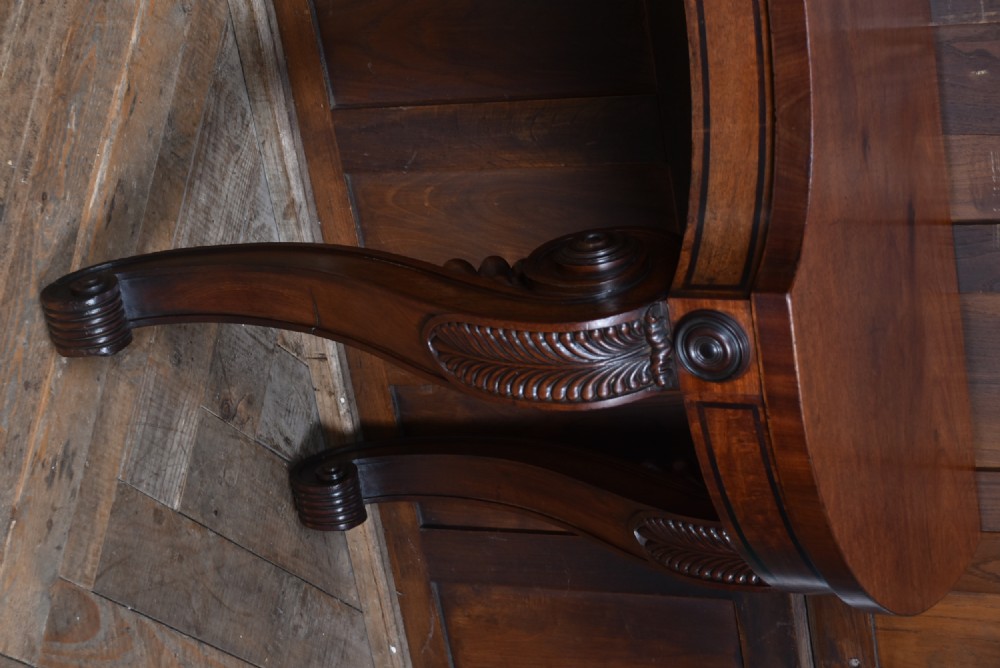 A 19th-century mahogany console table featuring a shaped top, inlaid frieze, and four carved scroll legs. View V