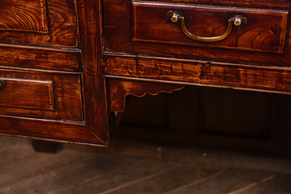 A traditional Chinese warm brown hardwood partners desk featuring six front drawers with brass drop handles and square legs. View V