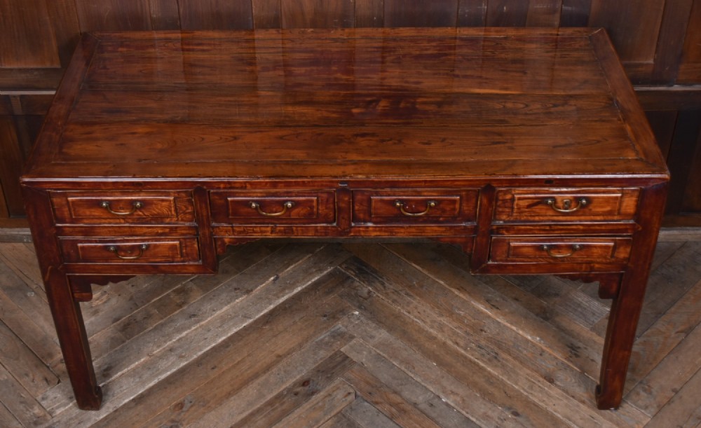 A traditional Chinese warm brown hardwood partners desk featuring six front drawers with brass drop handles and square legs. View VII