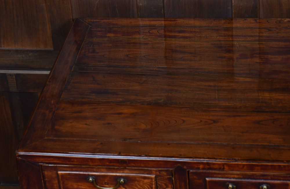 A traditional Chinese warm brown hardwood partners desk featuring six front drawers with brass drop handles and square legs. View VIII