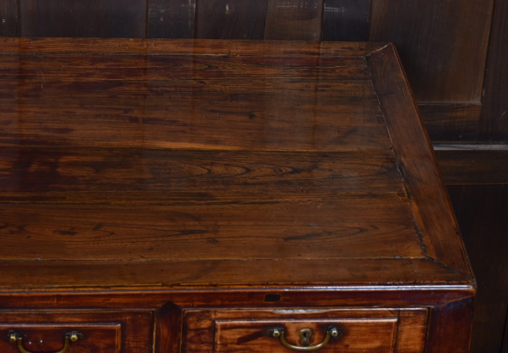 A traditional Chinese warm brown hardwood partners desk featuring six front drawers with brass drop handles and square legs. View IX