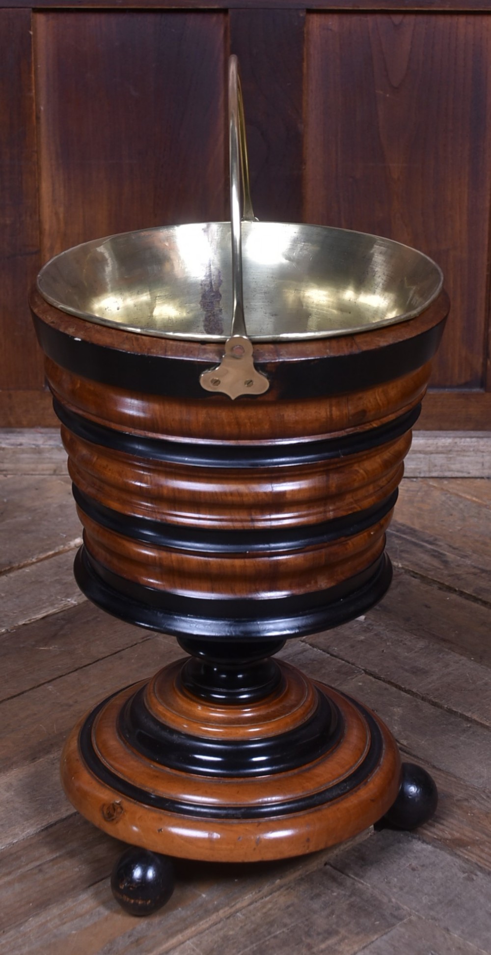 An early 19th-century Dutch teestoof bucket crafted from turned mahogany and ebonised wood with a brass swing handle and removable brass liner. View II