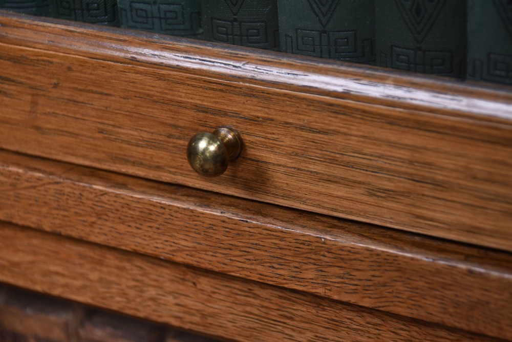 An Edwardian golden oak six-section bookcase featuring double columns of glass-fronted lifting doors and brass hardware. View IV