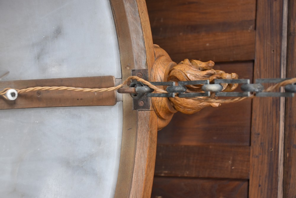 A pair of Art Deco ceiling lights featuring translucent veined alabaster bowls encased in carved wooden rims with flame finials and metal chains. View V