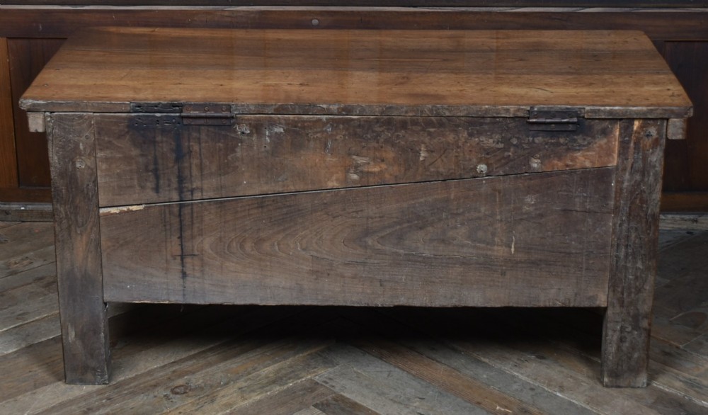 An antique French cherrywood blanket box with a hinged rectangular lid, natural wood grain, and shaped corner apron. View VII