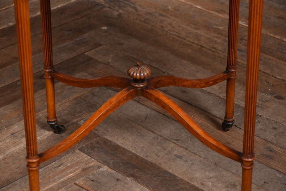 An Edwardian Neoclassical drop-leaf table featuring hand-painted floral swags, a central figural medallion, fluted turned legs, and an X-stretcher on castors. View VII
