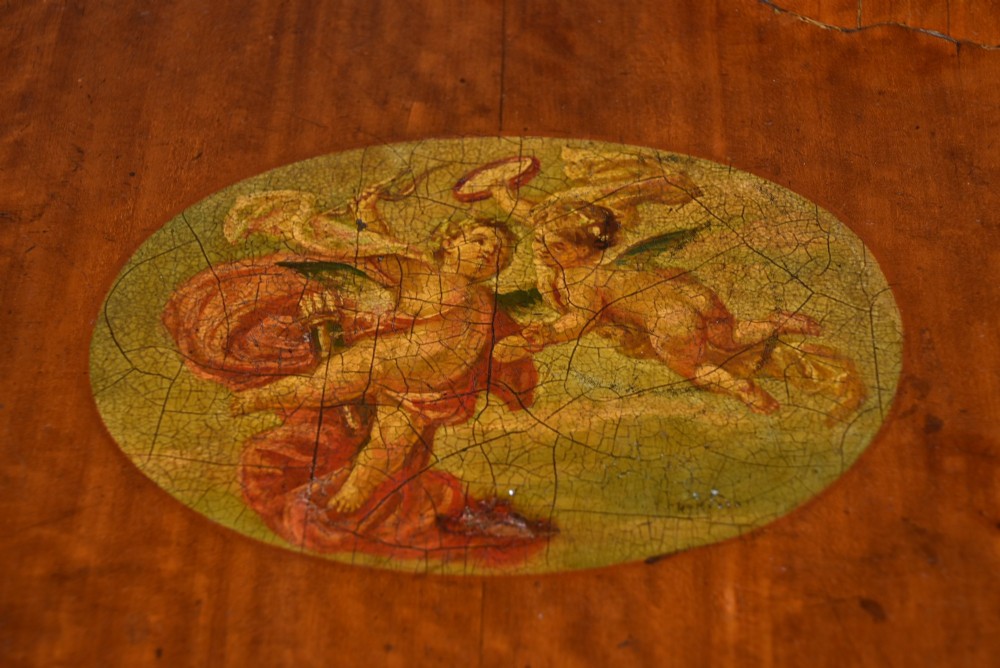 An Edwardian Neoclassical drop-leaf table featuring hand-painted floral swags, a central figural medallion, fluted turned legs, and an X-stretcher on castors. View XI