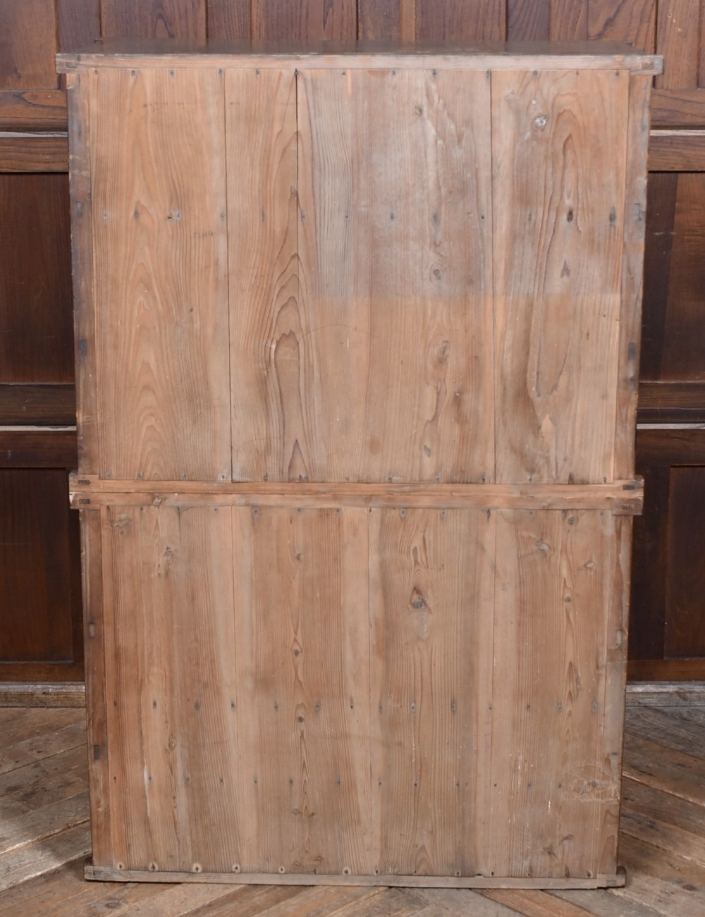 A tall wooden Japanese Mizuya tansu cabinet featuring multiple sliding door compartments, small drawers with iron drop handles, and faint calligraphic inscriptions on an upper panel. View VII