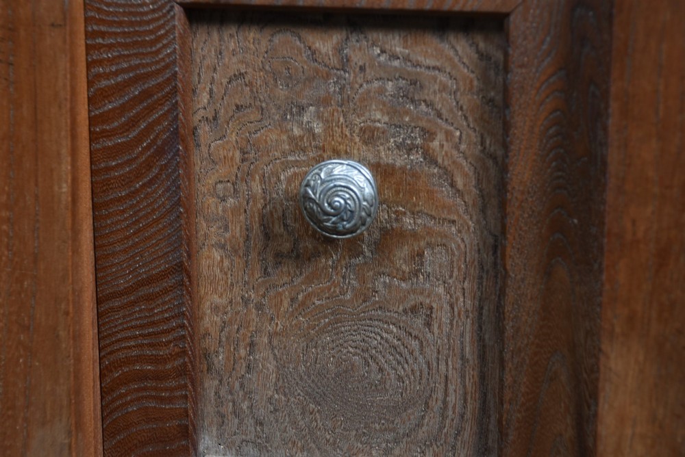 A tall wooden Japanese Mizuya tansu cabinet featuring multiple sliding door compartments, small drawers with iron drop handles, and faint calligraphic inscriptions on an upper panel. View IX