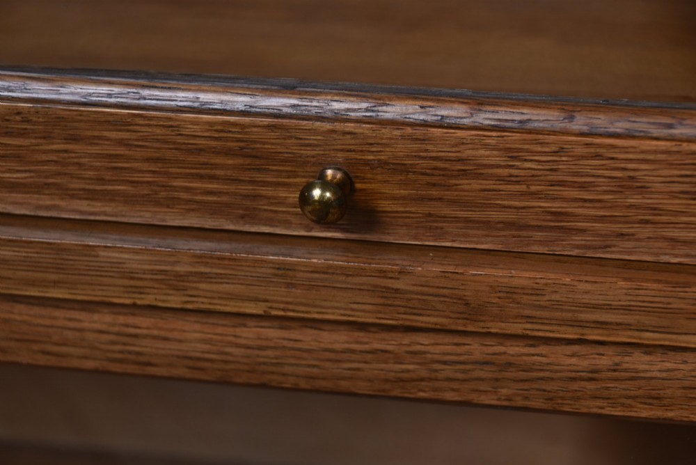 A three-tier Edwardian oak sectional bookcase featuring glass up-and-over doors with small brass knobs and a galleried top. View III