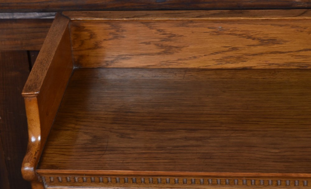 A three-tier Edwardian oak sectional bookcase featuring glass up-and-over doors with small brass knobs and a galleried top. View VII