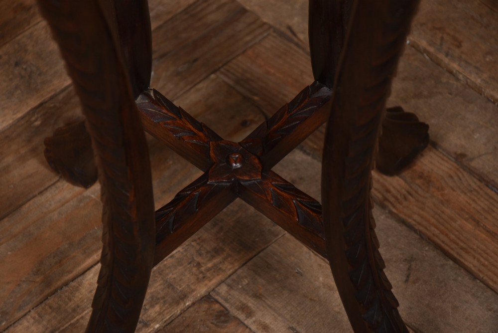 A tall dark hardwood Chinese plant stand featuring a round inset marble top, intricately carved floral aprons, and long swept legs joined by a lower central stretcher. View IX