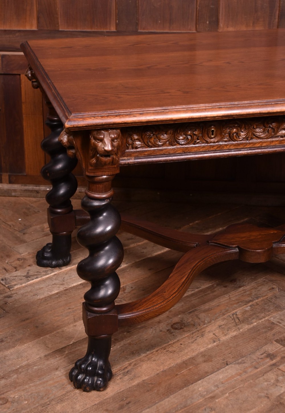 A 19th-century dark oak library table featuring barley twist legs, carved lion mask corners, an intricate apron, and an X-frame stretcher resting on paw feet. View II