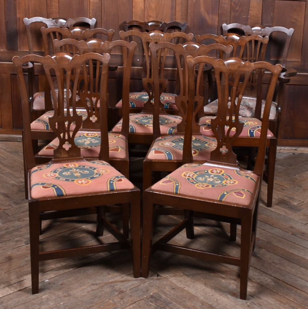 A set of ten dark brown wood dining chairs featuring carved pierced splat backs and patterned drop-in upholstered seats.