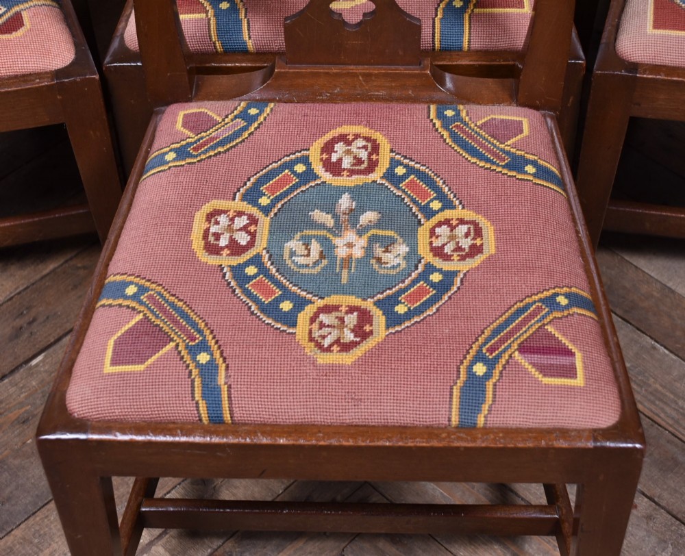A set of ten dark brown wood dining chairs featuring carved pierced splat backs and patterned drop-in upholstered seats. View III