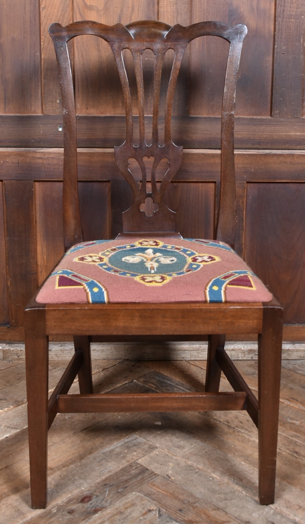 A set of ten dark brown wood dining chairs featuring carved pierced splat backs and patterned drop-in upholstered seats. View IX