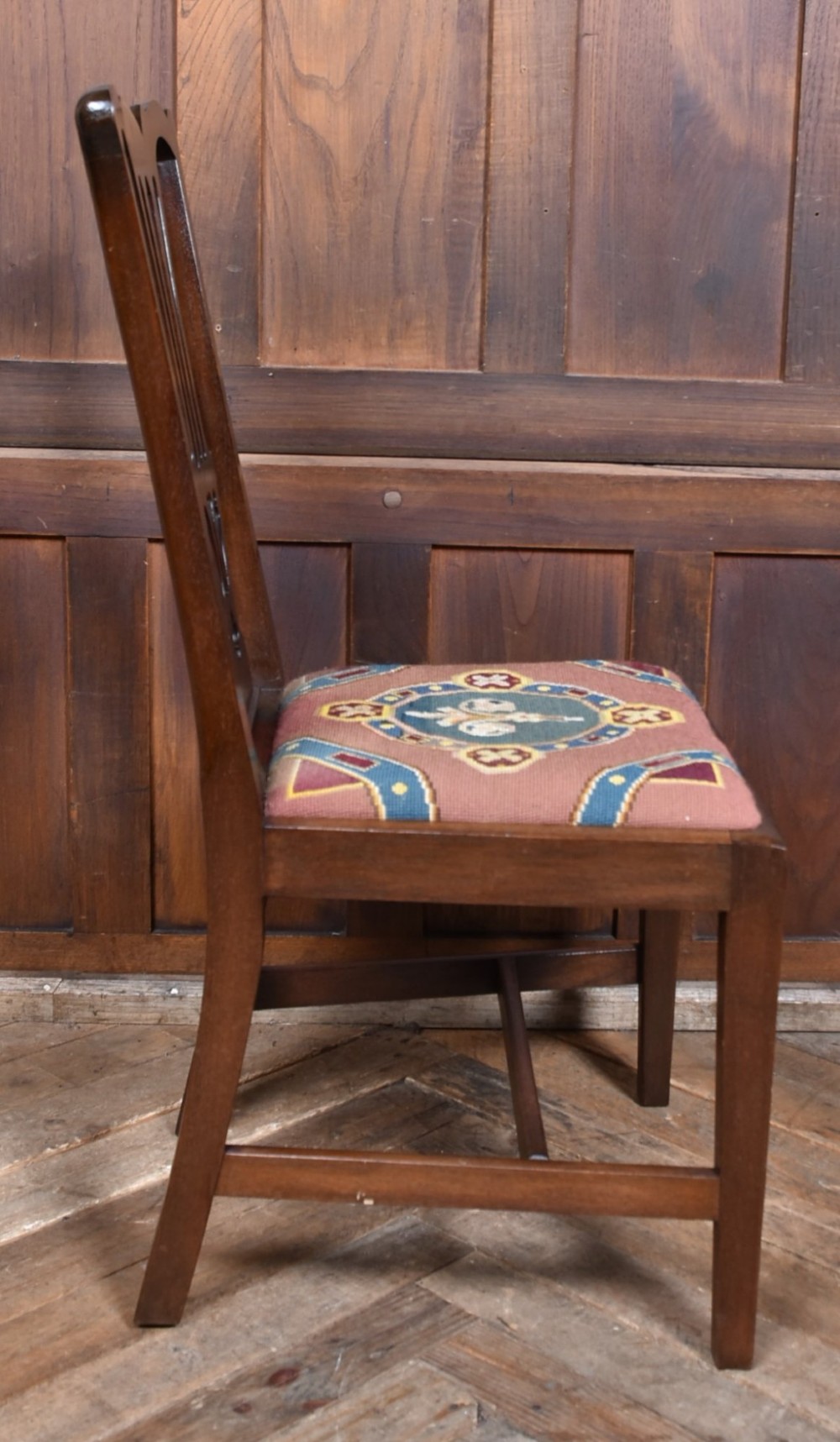A set of ten dark brown wood dining chairs featuring carved pierced splat backs and patterned drop-in upholstered seats. View X