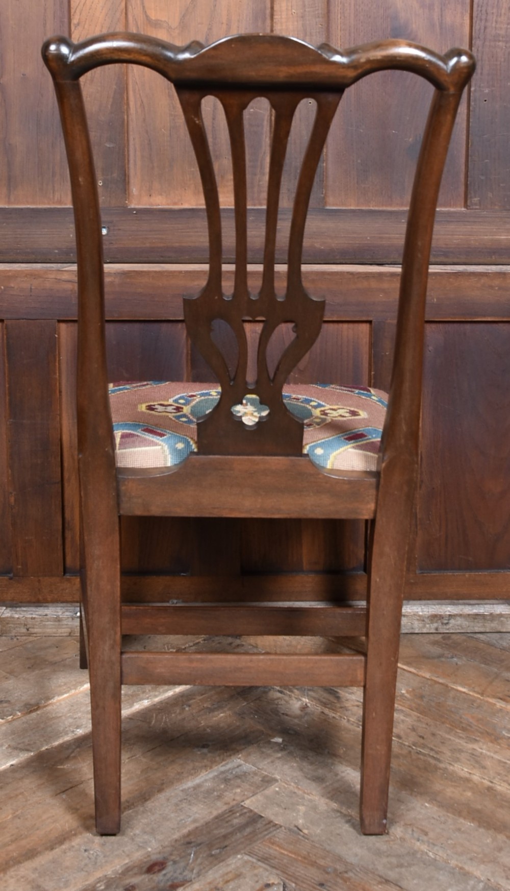 A set of ten dark brown wood dining chairs featuring carved pierced splat backs and patterned drop-in upholstered seats. View XI