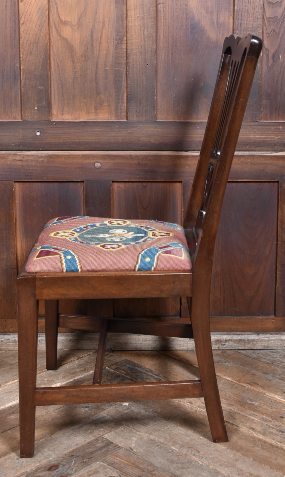 A set of ten dark brown wood dining chairs featuring carved pierced splat backs and patterned drop-in upholstered seats. View XII