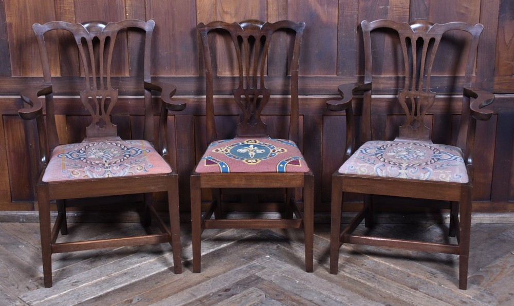A set of ten dark brown wood dining chairs featuring carved pierced splat backs and patterned drop-in upholstered seats. View XIII