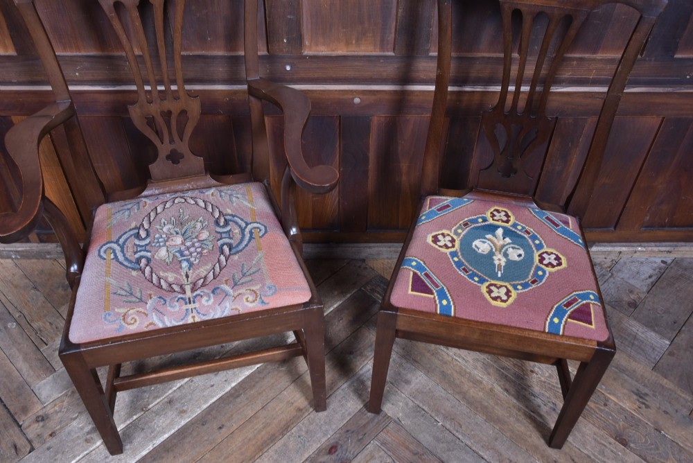 A set of ten dark brown wood dining chairs featuring carved pierced splat backs and patterned drop-in upholstered seats. View XV