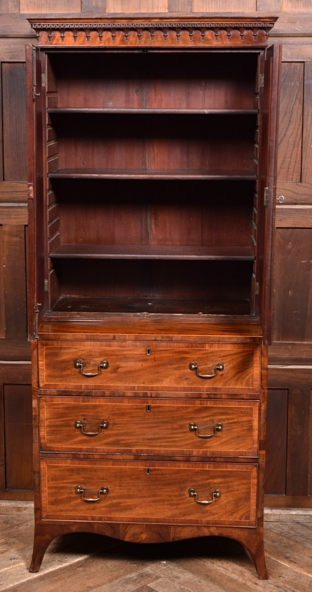A tall Georgian mahogany secretaire bookcase featuring an upper two-door cabinet with oval inlay panels above a lower chest with four drawers and brass swan-neck handles. View III