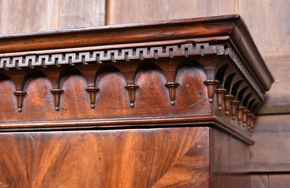 A tall Georgian mahogany secretaire bookcase featuring an upper two-door cabinet with oval inlay panels above a lower chest with four drawers and brass swan-neck handles. View V
