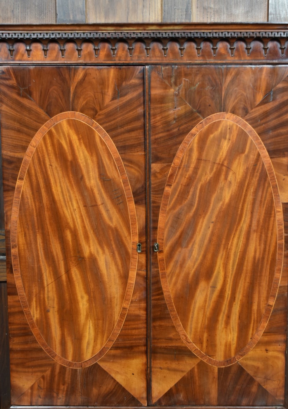 A tall Georgian mahogany secretaire bookcase featuring an upper two-door cabinet with oval inlay panels above a lower chest with four drawers and brass swan-neck handles. View XIII